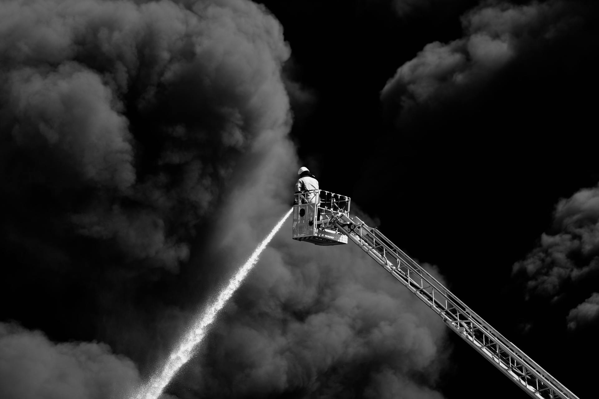 Firefighter on a Crane Extinguishing a Large Fire