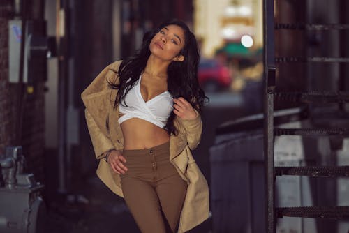 A Portrait of a Woman in a Brown Coat and Brown Pants