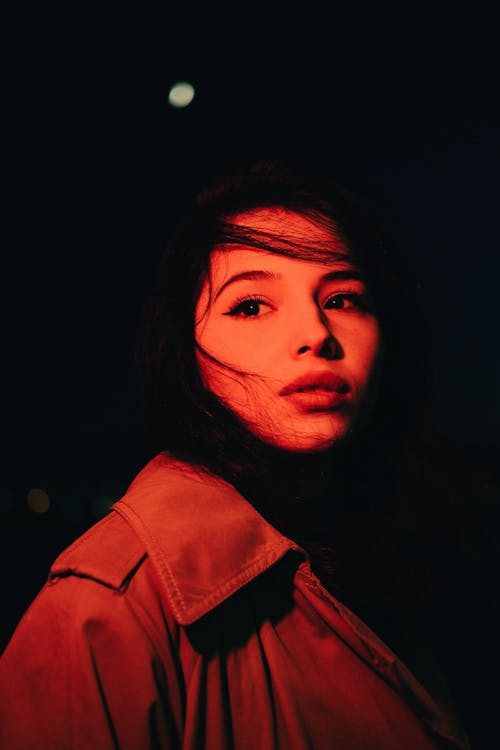 Portrait of Woman Wearing Coat with Red Light Reflection