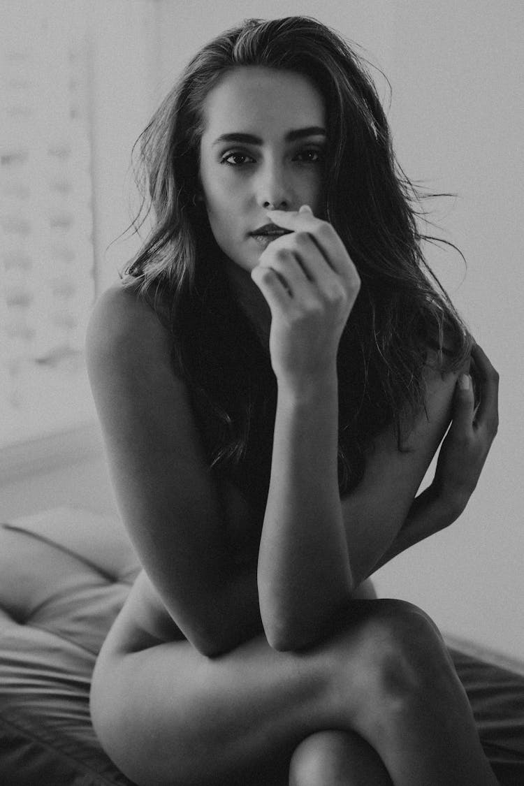 Naked Woman Sitting On Bed In Black And White