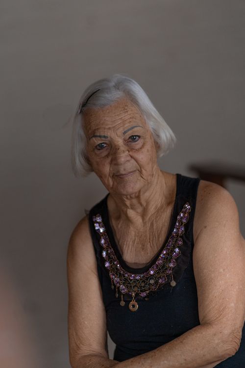 Free A serene portrait of an elderly woman with gray hair and an ornate blouse, exuding grace and wisdom. Stock Photo