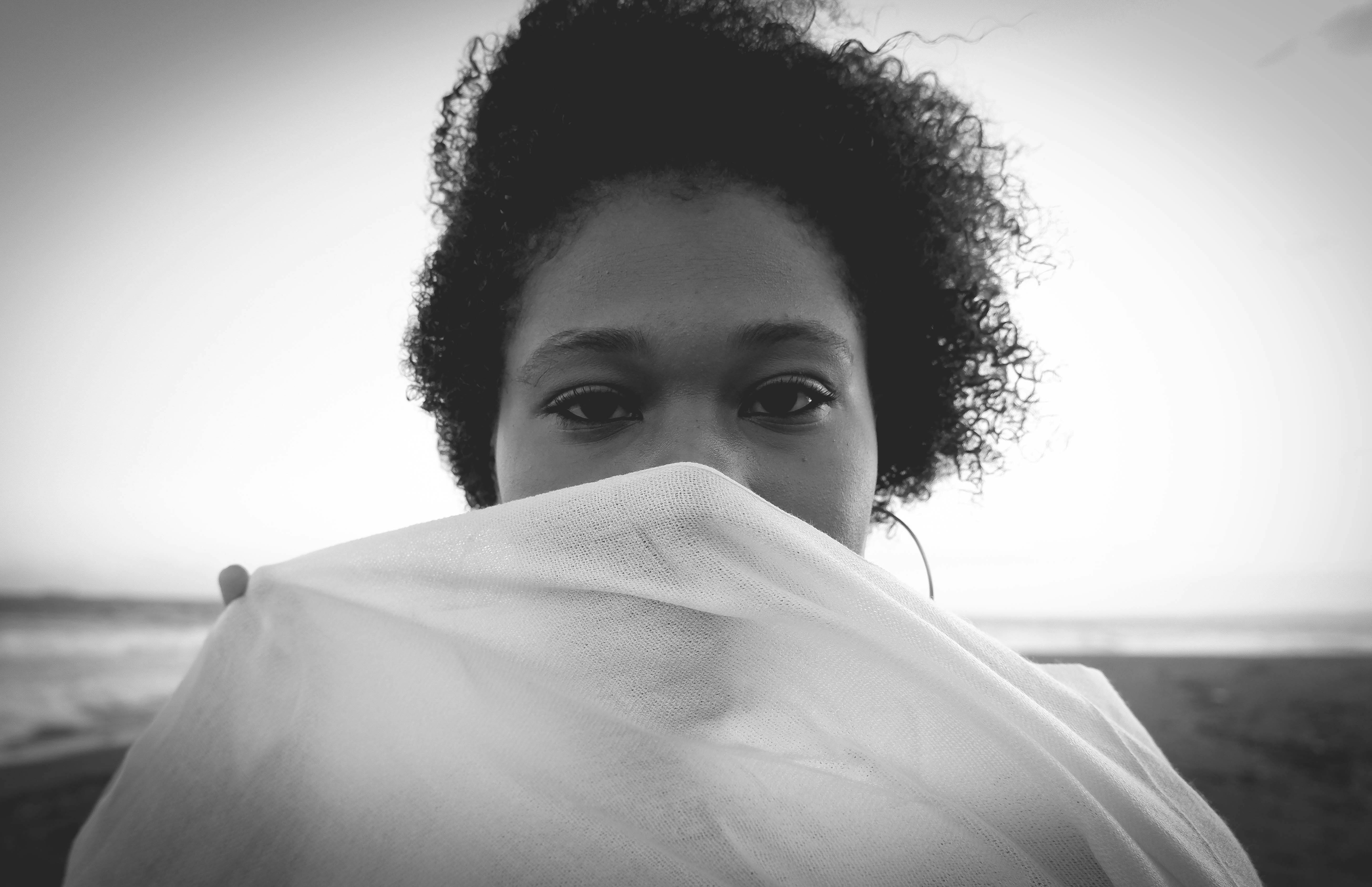 Artistic black-and-white portrait of a woman with mysterious expression and curly hair. - Kingston