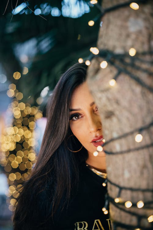 Woman Face behind Lights on Tree