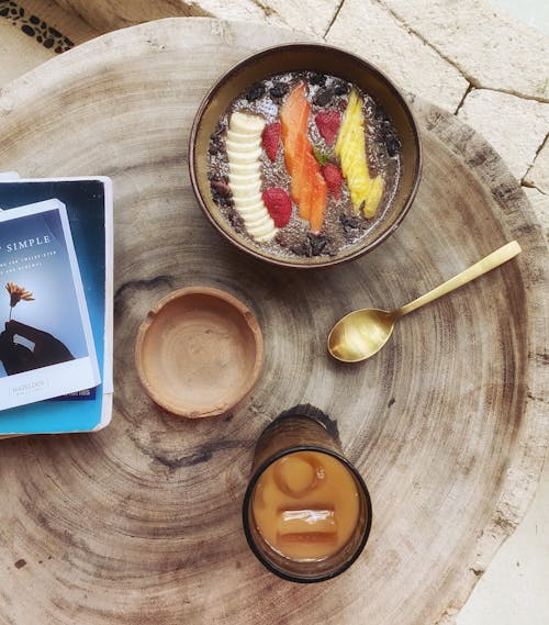 A Flatlay of a Smoothie Bowl and an Iced Tea on a Wooden Table