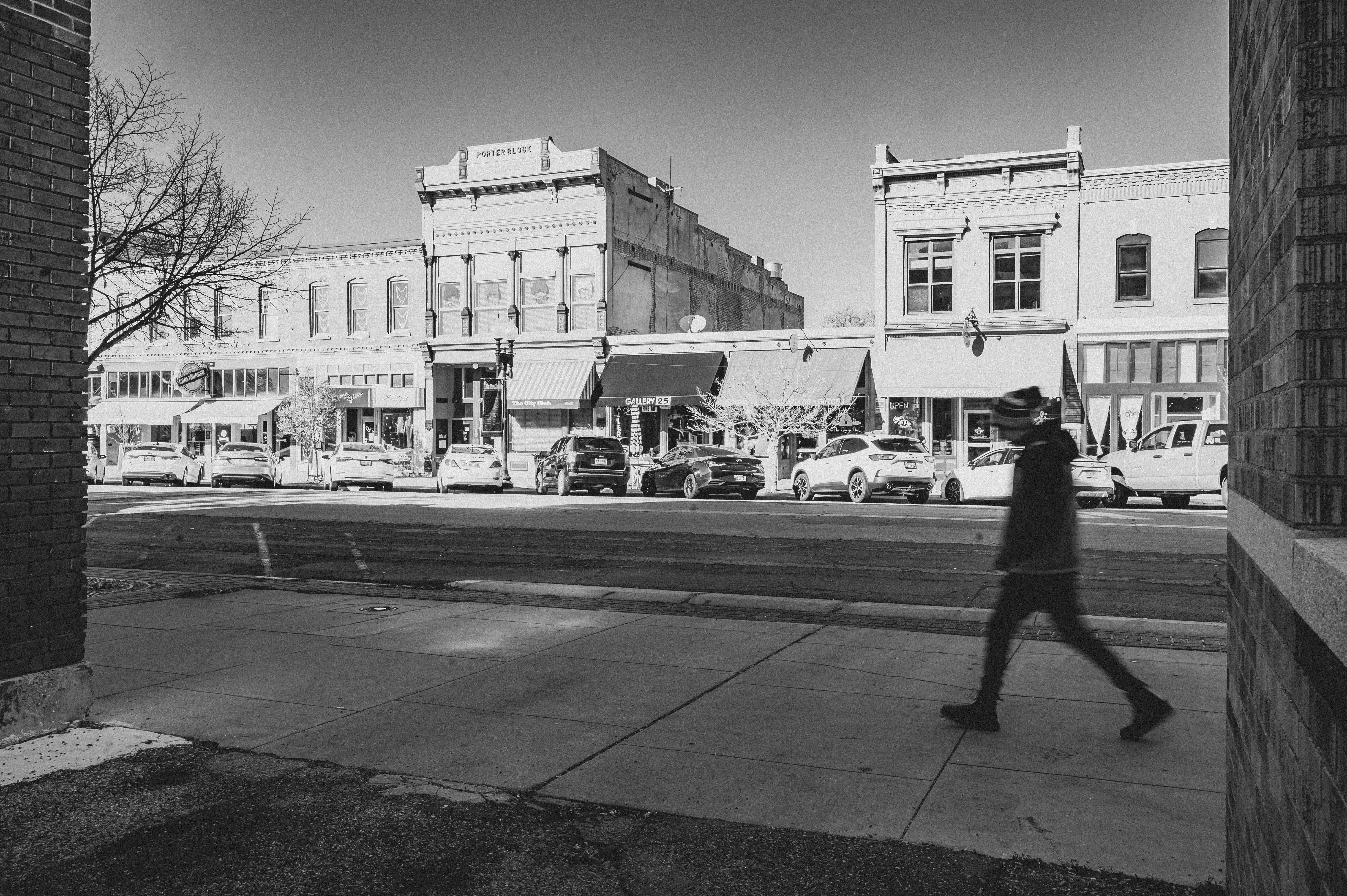 Person Walking on Sidewalk in Town in Black and White · Free Stock Photo