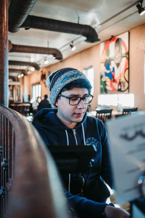 A Man Wearing a Hoodie and a Bonnet  in a Café