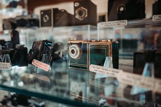 A collection of vintage cameras displayed in a glass case at a museum.