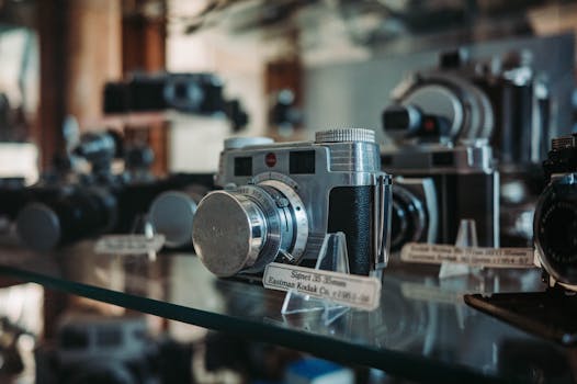 Close-up of vintage cameras displayed with labels at a museum. Collectible photography history.