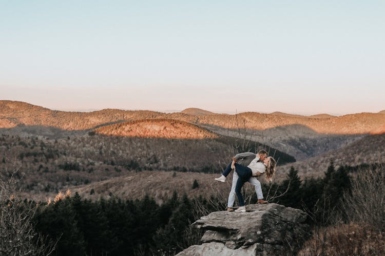 Man Dipping And Kissing His Wife On A Rock Formation