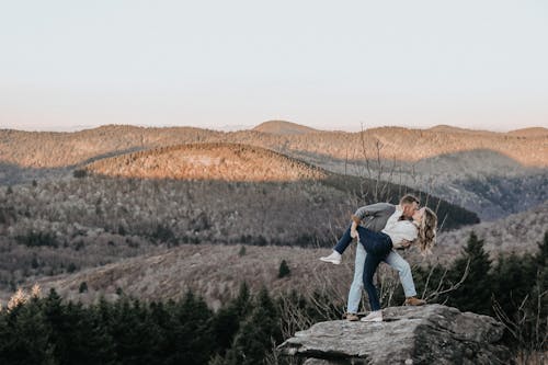 Couple Kissing with the View of the Hills