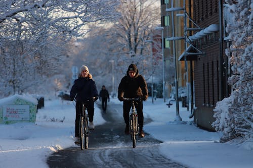 Man and Woman Riding Bicycle During Winter