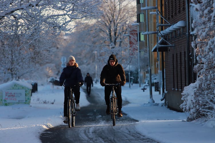 Man And Woman Riding Bicycle During Winter