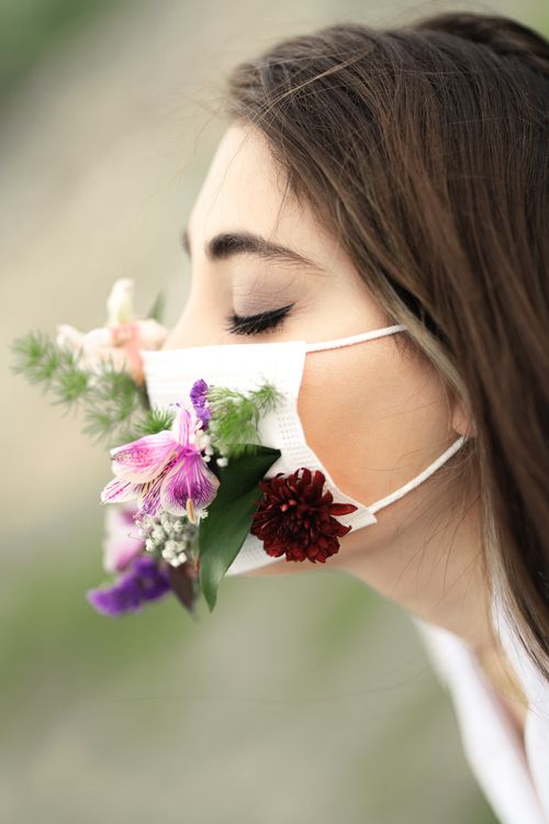 Free Close-up of a woman wearing a floral face mask to symbolize nature and protection. Stock Photo