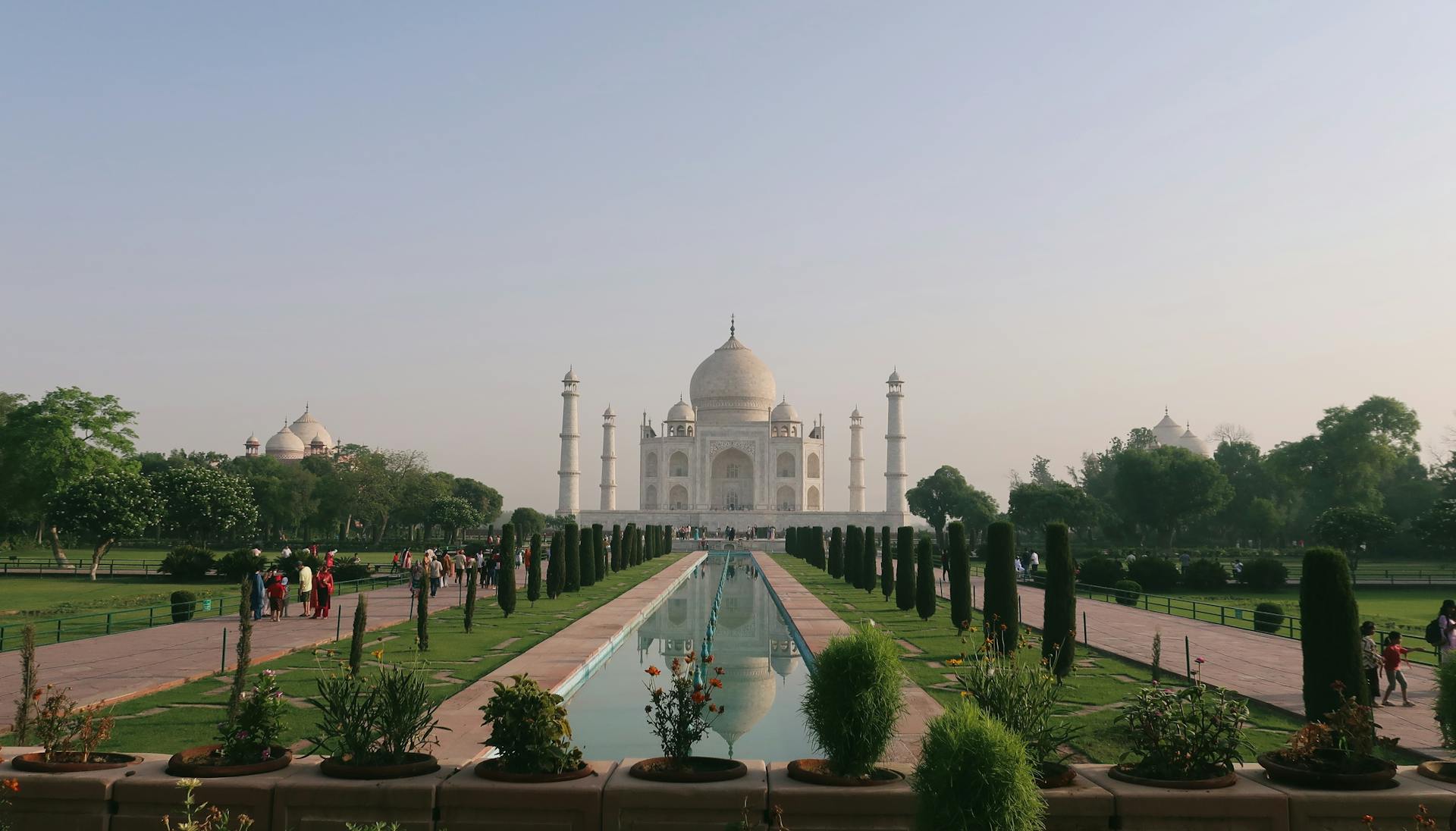 Stunning perspective of the Taj Mahal in Agra, India, captured at sunrise with its reflection in the water.