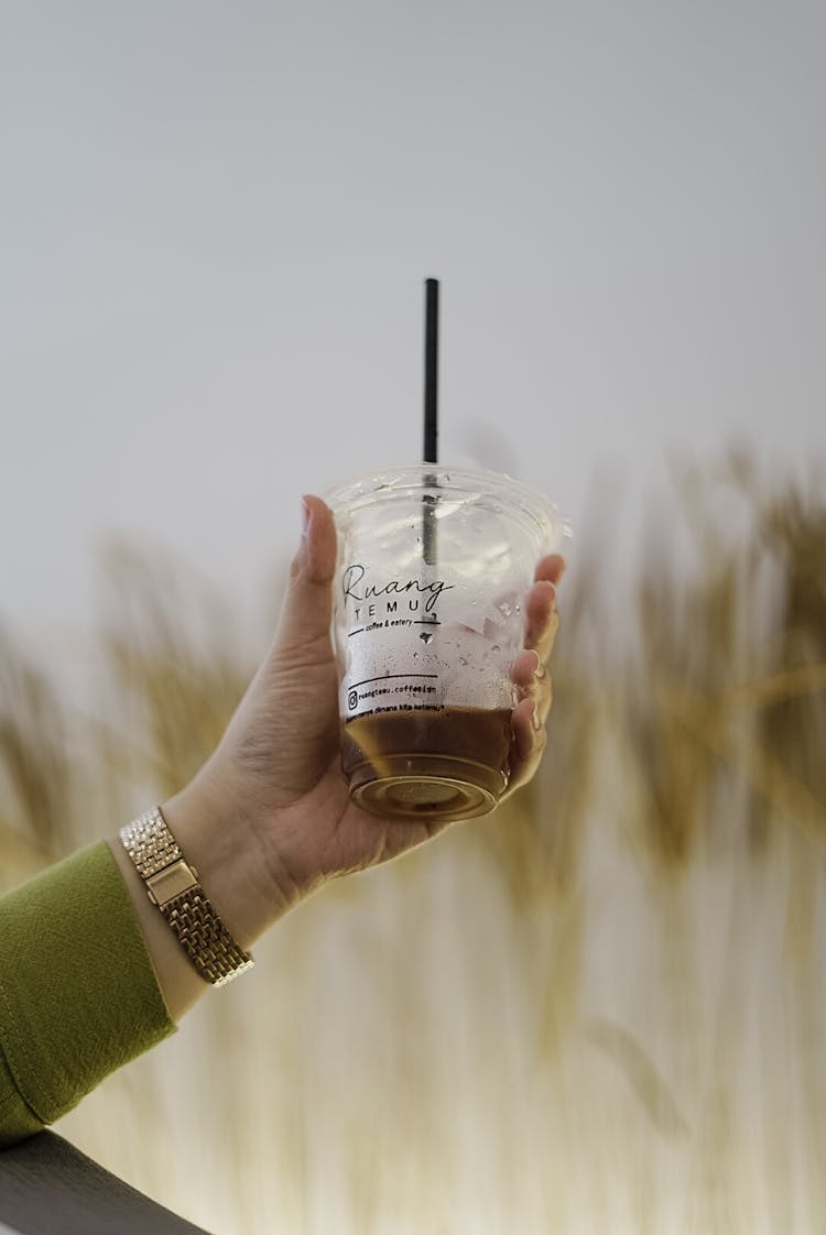 Woman Hand Holding Coffee In Plastic Cup