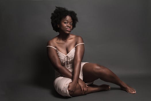 Elegant portrait of a woman sitting in a studio, showcasing confidence and natural beauty.