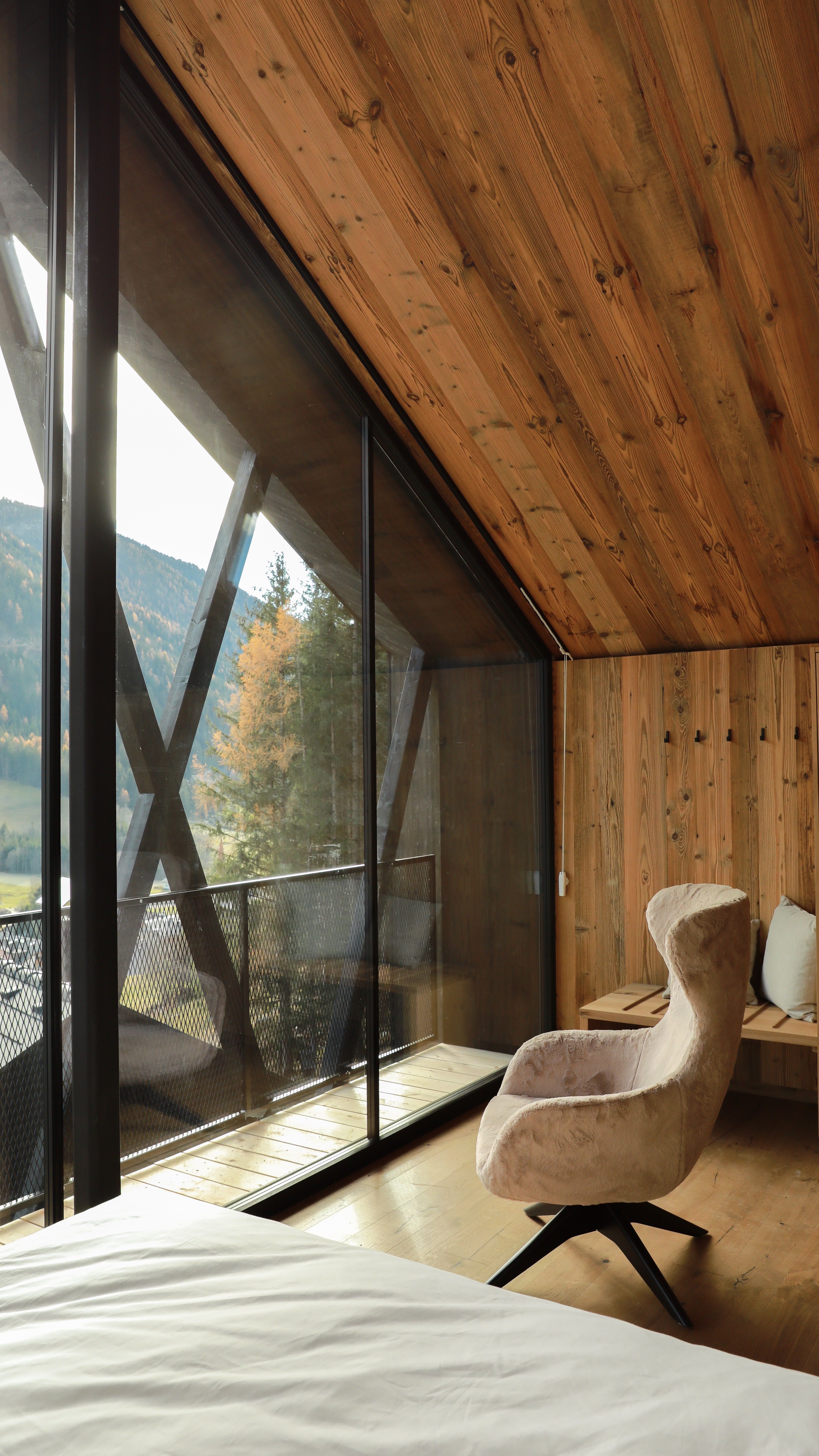 Modern interior with armchair and mountain view in Antholz, Italy.