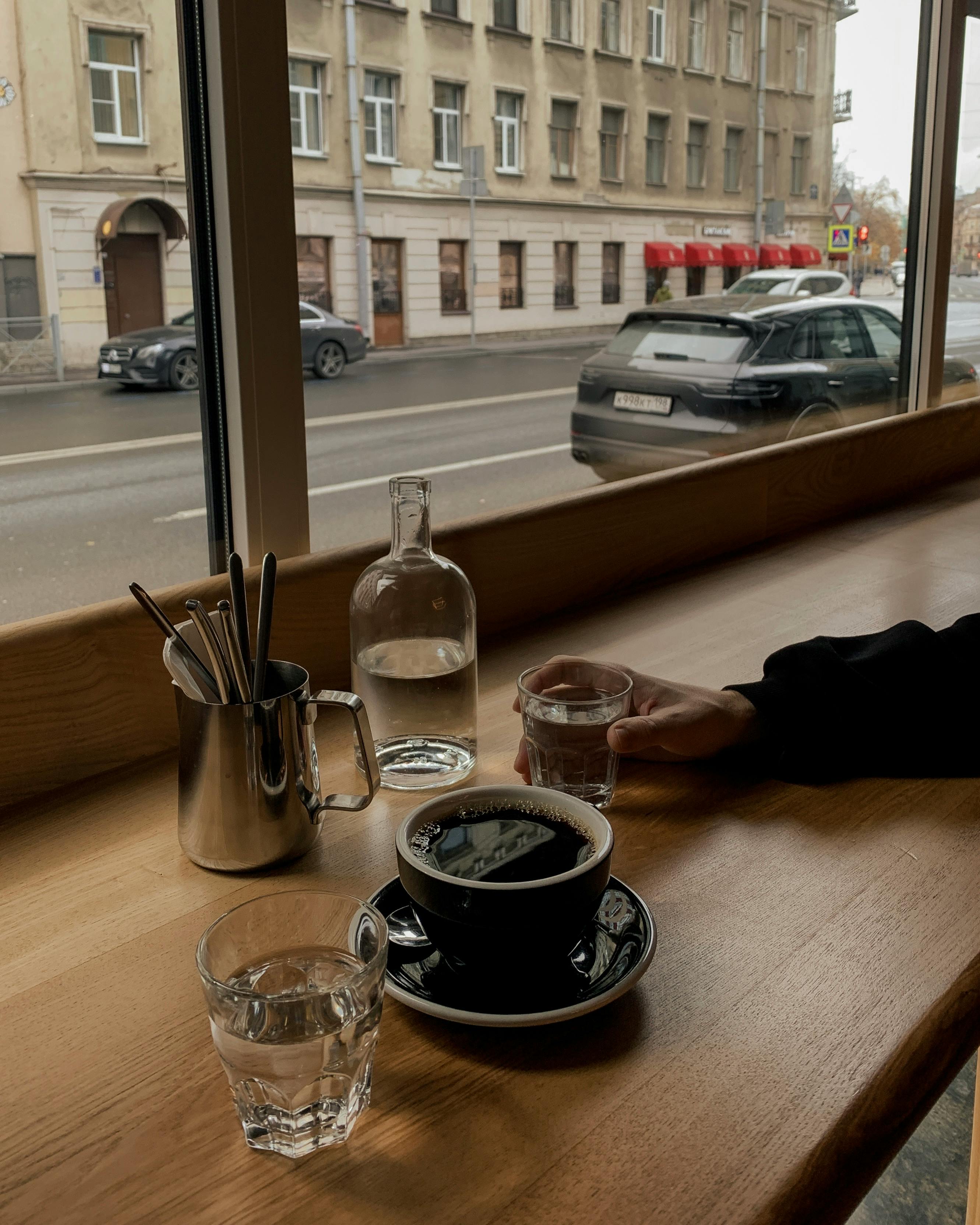 coffee and water on cafe table near window