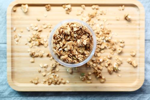Free Crunchy granola in a jar on a wooden board, perfect for healthy breakfast ideas. Stock Photo