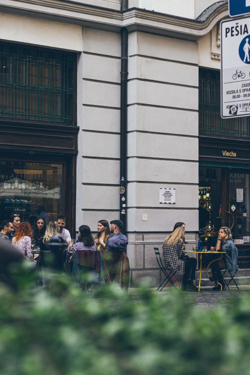 Free People enjoying meals at an outdoor city cafe, capturing urban lifestyle vibes. Stock Photo