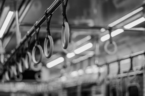 Free Close-up of hanging handrails in a Jakarta train, black and white image emphasizing urban transport. Stock Photo