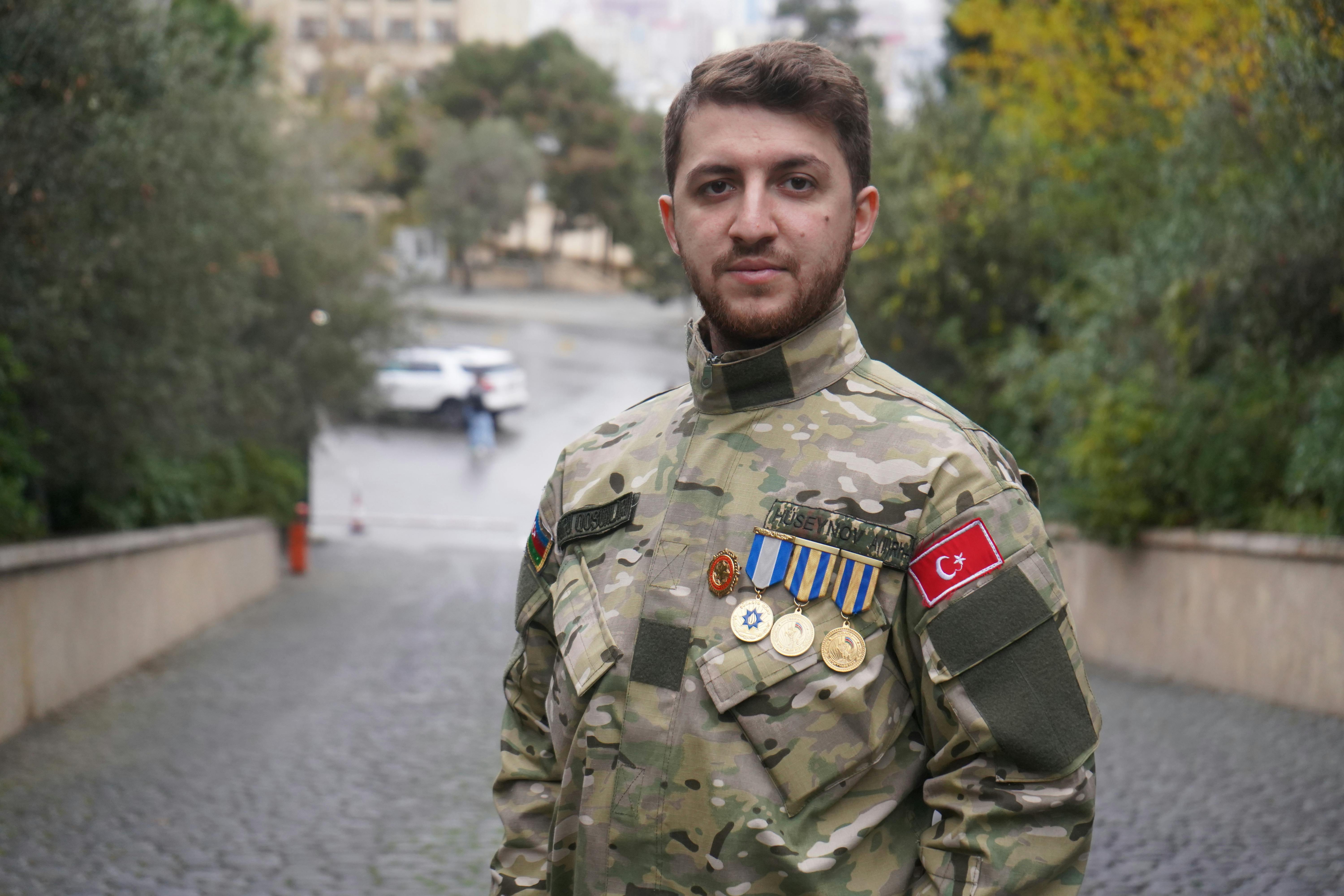 man in a military uniform standing in a street