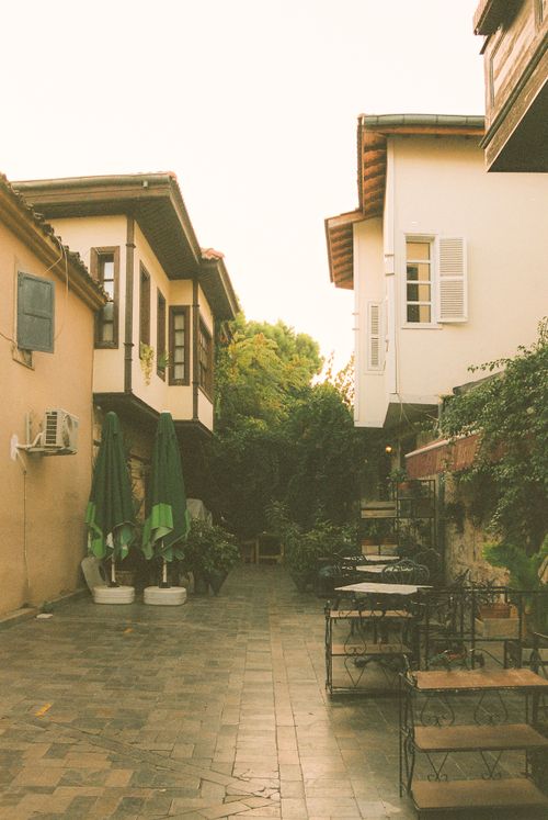 Free Peaceful alley with vintage architecture and lush plants, perfect retreat Stock Photo