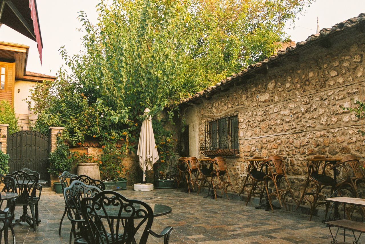 charming rustic garden caf featuring empty chairs tables stone wall an