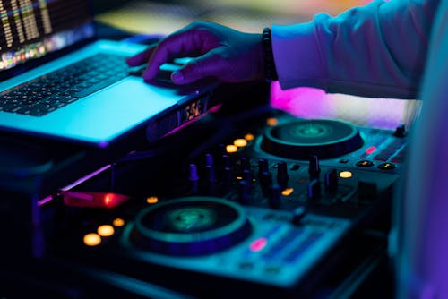 DJ Hand on Laptop over Sound Mixer