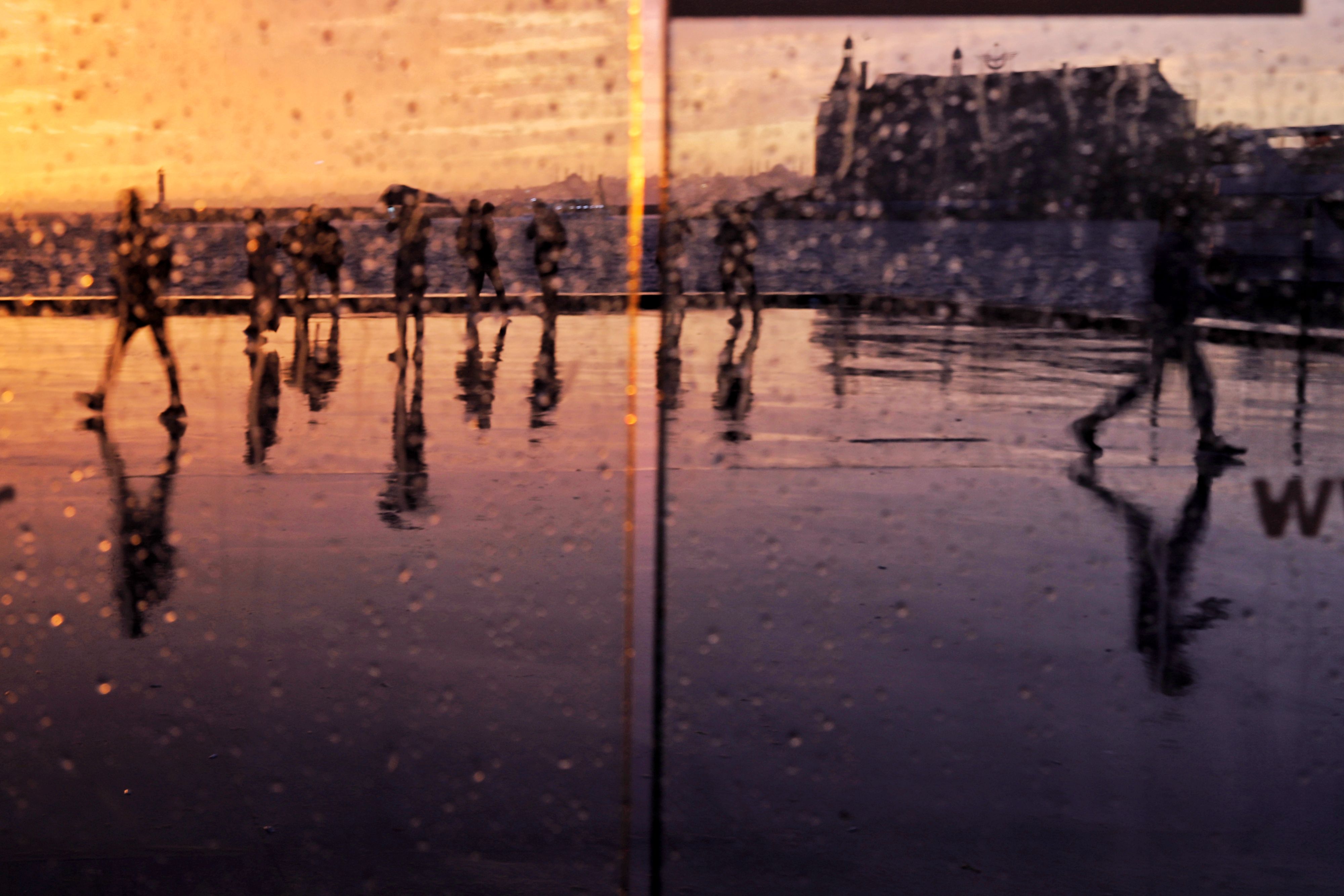 People Walking at Sunset behind Window in Rain · Free Stock Photo
