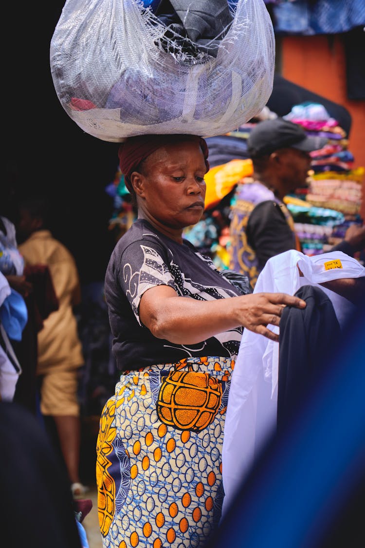 Woman With Bag On Head Looking At Clothes