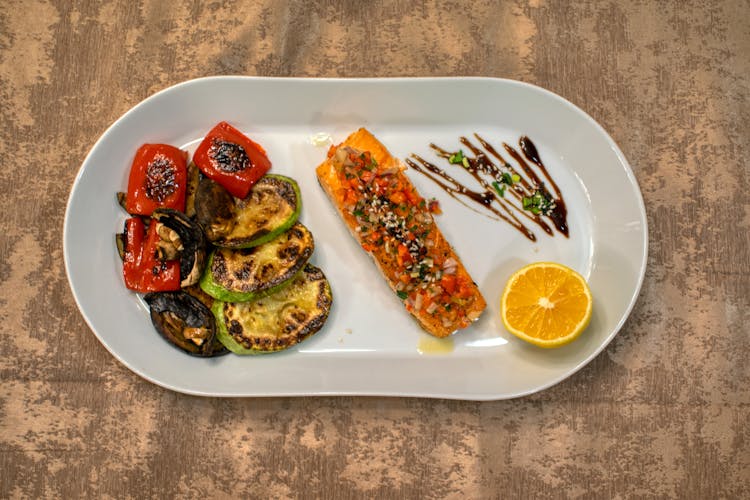 Grilled Vegetables And Fish Served On White Plate