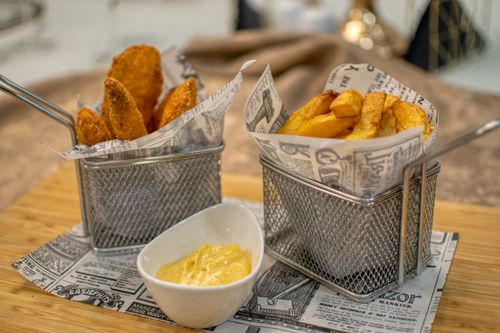 Free Delicious crispy french fries served in metal baskets with dipping sauce. Stock Photo