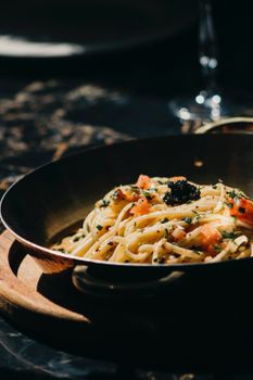 A close-up of gourmet shrimp pasta with herbs in a rustic setting, perfect for food photography.