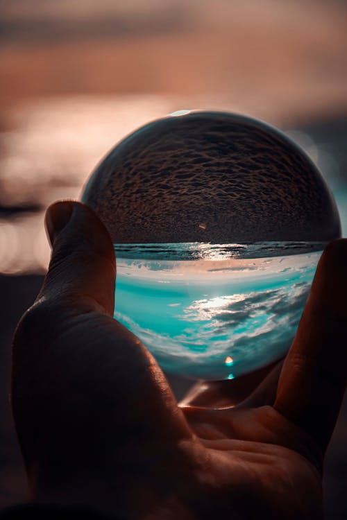 Person Holding Ball Showing Seashore