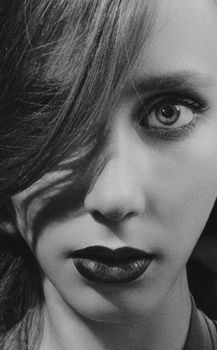 Close-up black and white portrait of a woman with dramatic lighting, shadow effect.