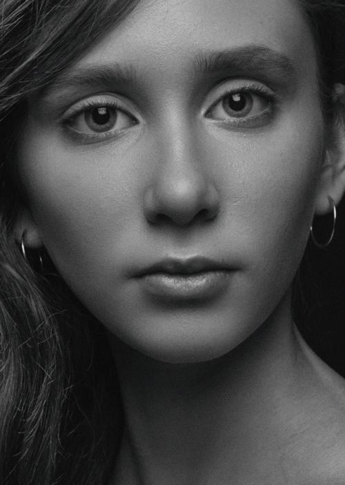 Free Close-up black and white portrait of a young woman showcasing her natural beauty. Stock Photo