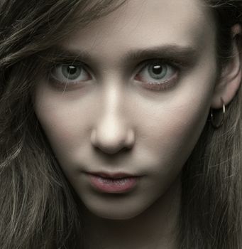 Intense close-up portrait showcasing the captivating gaze of a young woman.