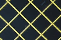 Yellow Crossbar Fence against Black Ba