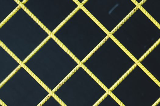 Yellow Crossbar Fence against Black Ba