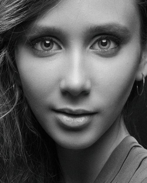 Free Close-up black and white portrait of a woman with striking eyes and gentle expression. Stock Photo