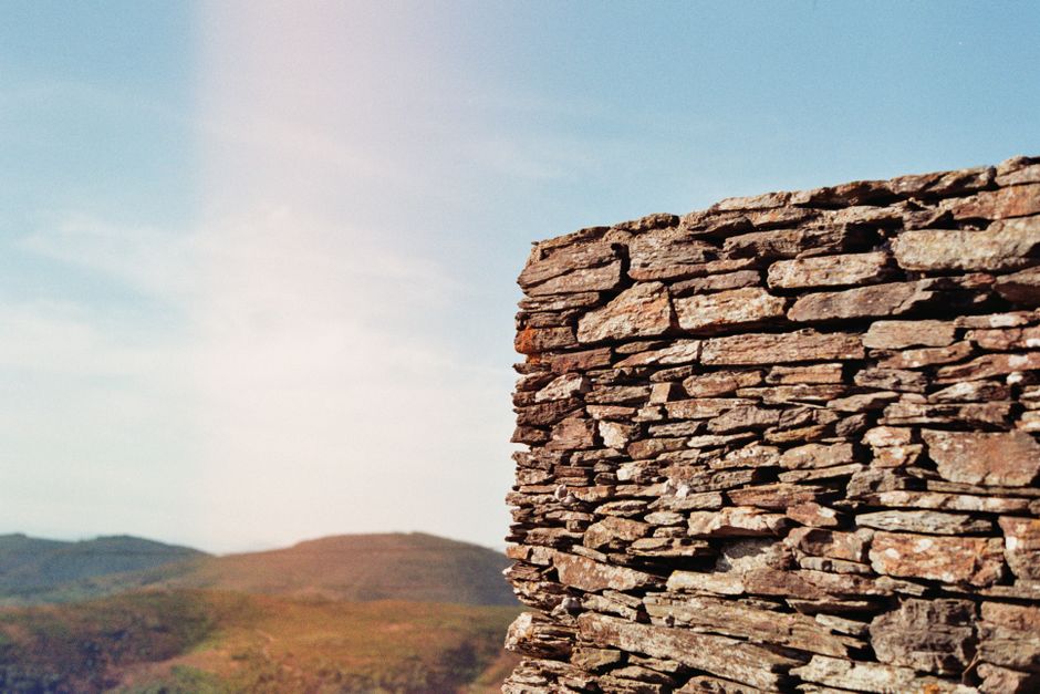 Rustic stone wall overlooking scenic mountains in Arouca, Portugal.
