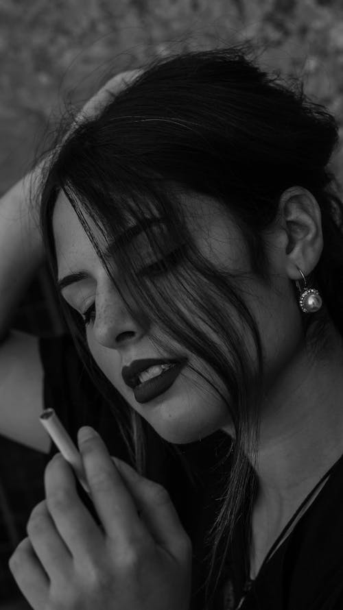 Grayscale Photo of Woman Holding a Cigarette