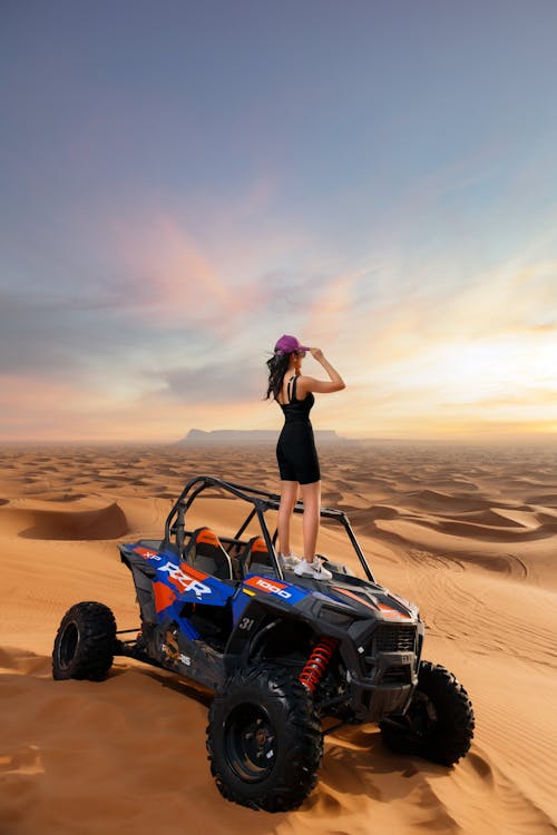 A Woman Standing on a Quad Bike in the Desert
