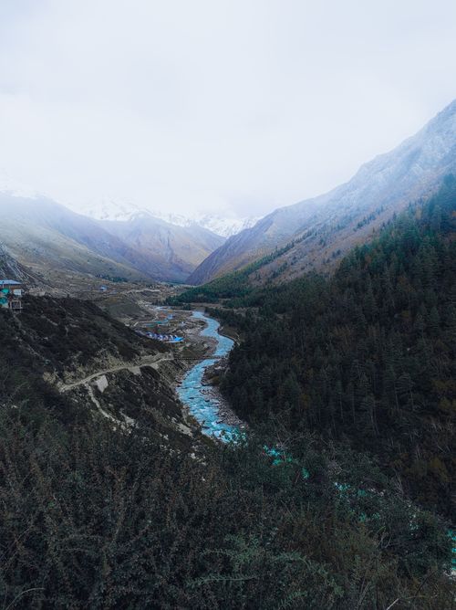 Free A breathtaking aerial view of a winding river cutting through a lush mountain valley, showcasing nature's beauty. Stock Photo
