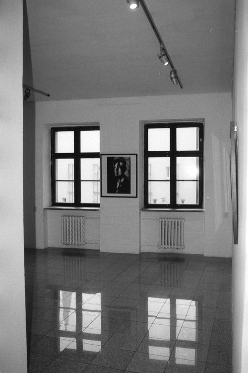 Free Empty art gallery room with two windows and black and white portrait on white wall. Stock Photo