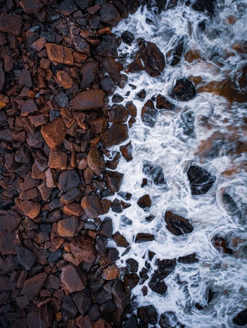 View of Foamy Water between Pebbles 