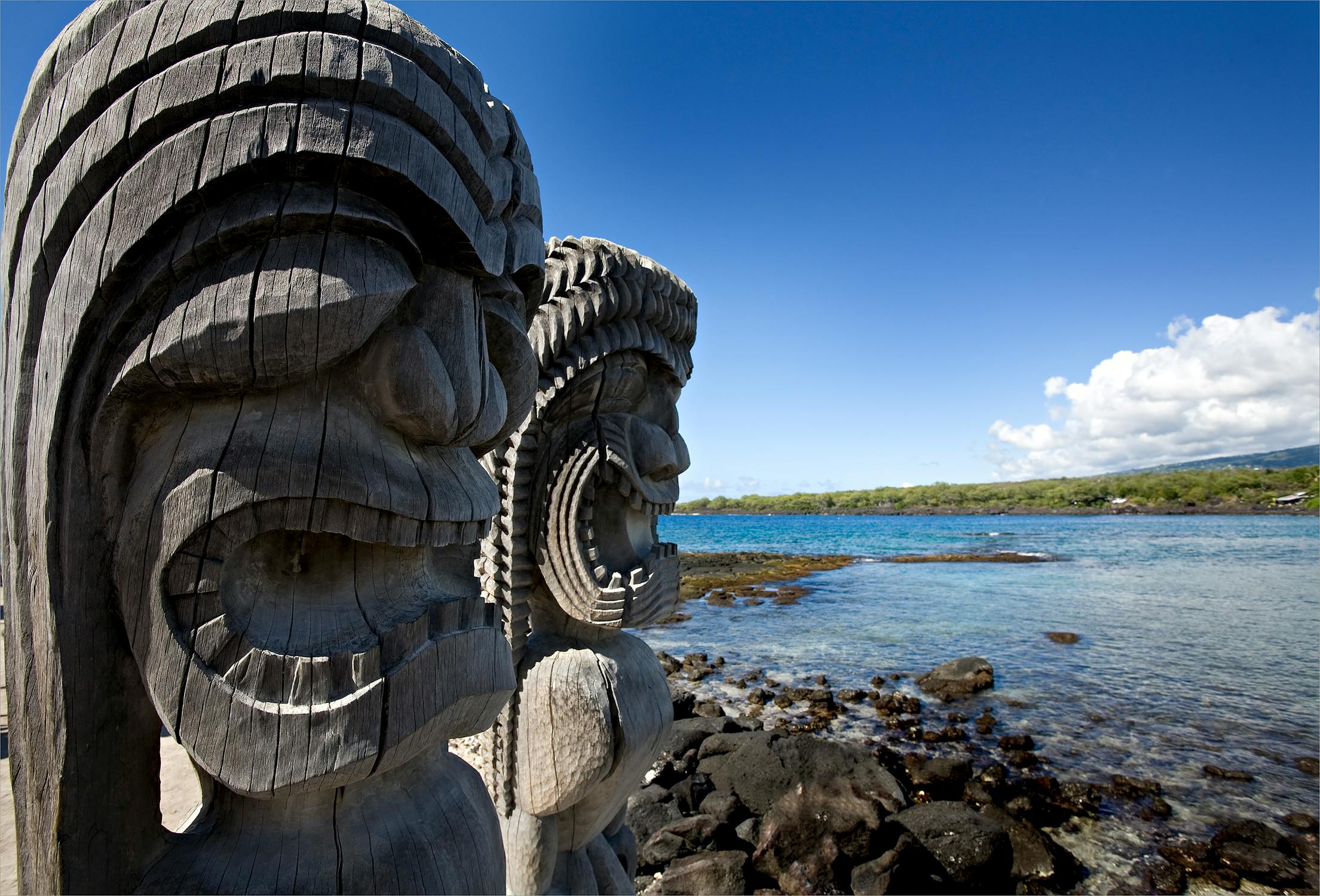Two ancient wooden tiki sculptures of Pu`uhonua o Honaunau at National Park, Hawaii