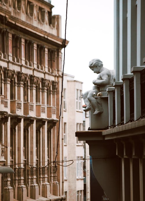 Sculpture on Wall between Buildings in City
