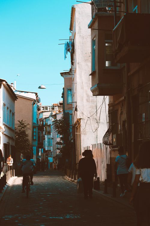 Free Street scene with pedestrians and historic buildings under a clear sky. Stock Photo